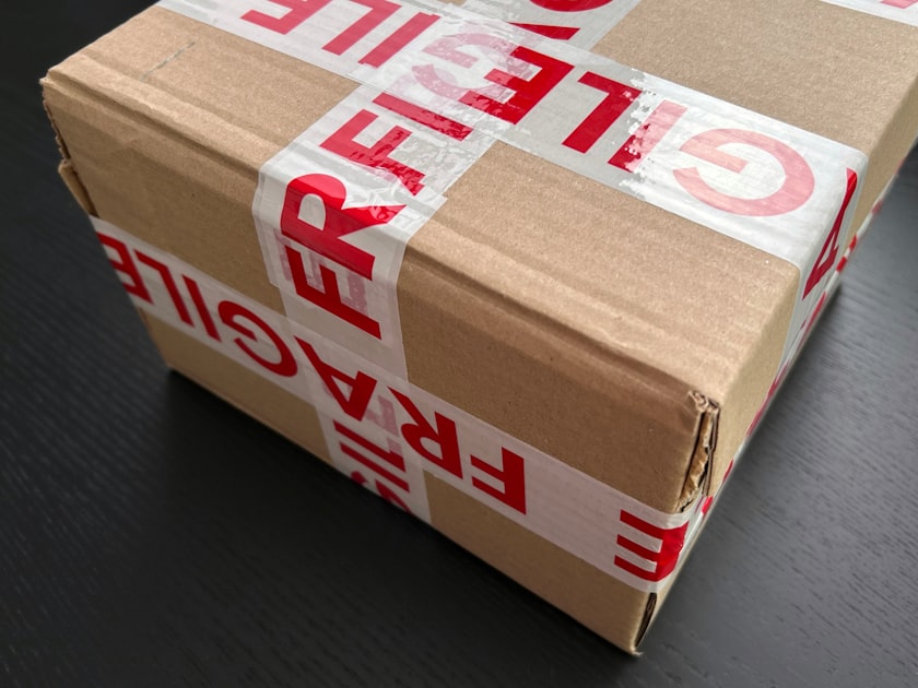Cardboard box sealed with red fragile tape — Gửi Quà Về Quê Từ Ocean Park - Nhanh, An Toàn, Giá Rẻ