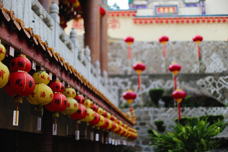 a row of red and yellow lanterns hanging from the side of a building — Quẻ Địa Lôi Phục - Luận Số Điện Thoại Kinh Dịch