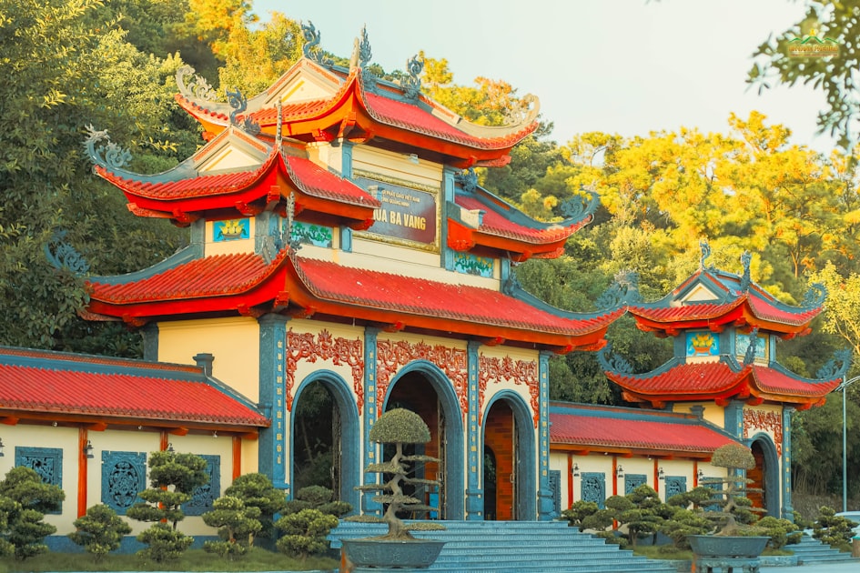 A building with red and blue roofing next to a body of water — Quẻ Địa Phong Thăng - Luận Số Điện Thoại Kinh Dịch