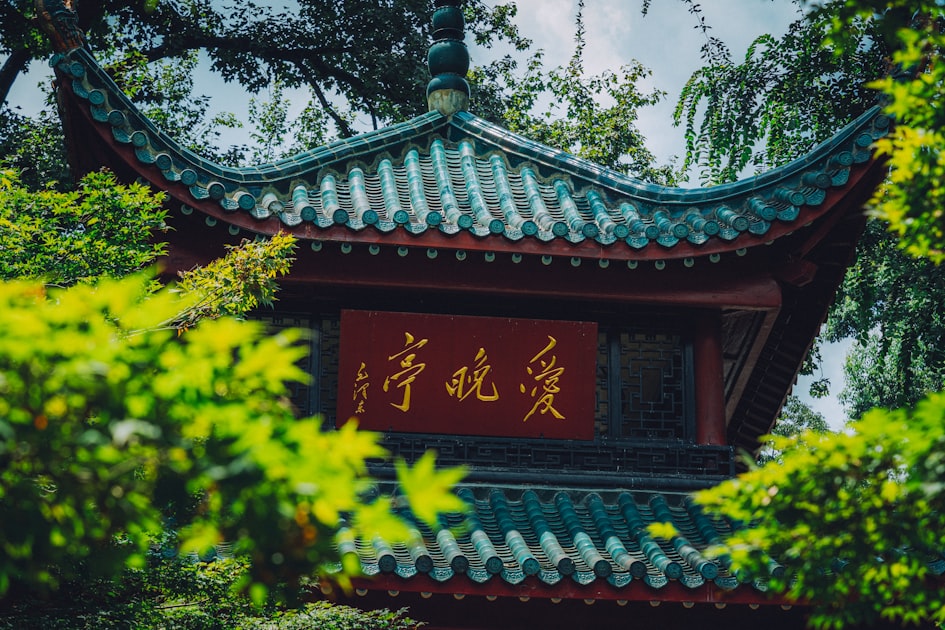 A chinese pagoda sits amidst green foliage — Quẻ Thiên Lôi Vô Vọng - Luận Số Điện Thoại Kinh Dịch