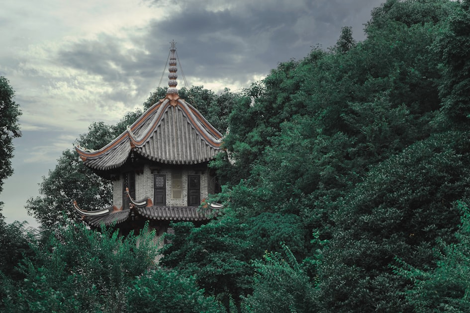 a tall building surrounded by trees under a cloudy sky — Quẻ Thủy Thiên Nhu - Luận Số Điện Thoại Kinh Dịch