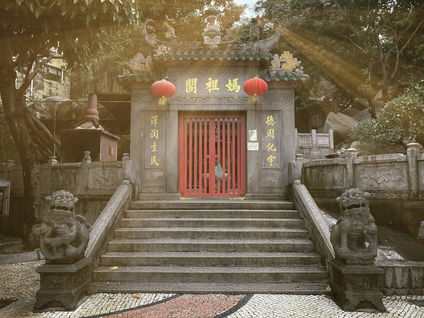 a chinese temple with a red door surrounded by stone statues — Quẻ Trạch Sơn Hàm - Luận Số Điện Thoại Kinh Dịch