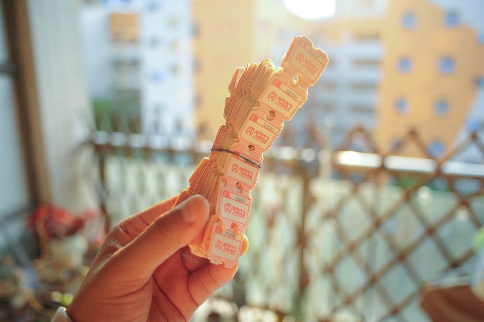 Hand holding a stack of small pink and white tickets — Sim Hợp Năm Sinh 1986 (Bính Dần) - Mệnh Hỏa