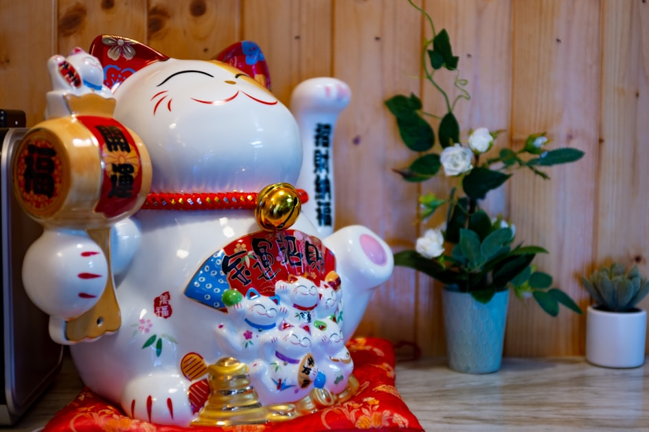 red and white ceramic cat figurine — Sim Tam Hoa: Ý Nghĩa, Mẫu Số & Cách Chọn Hợp Mệnh