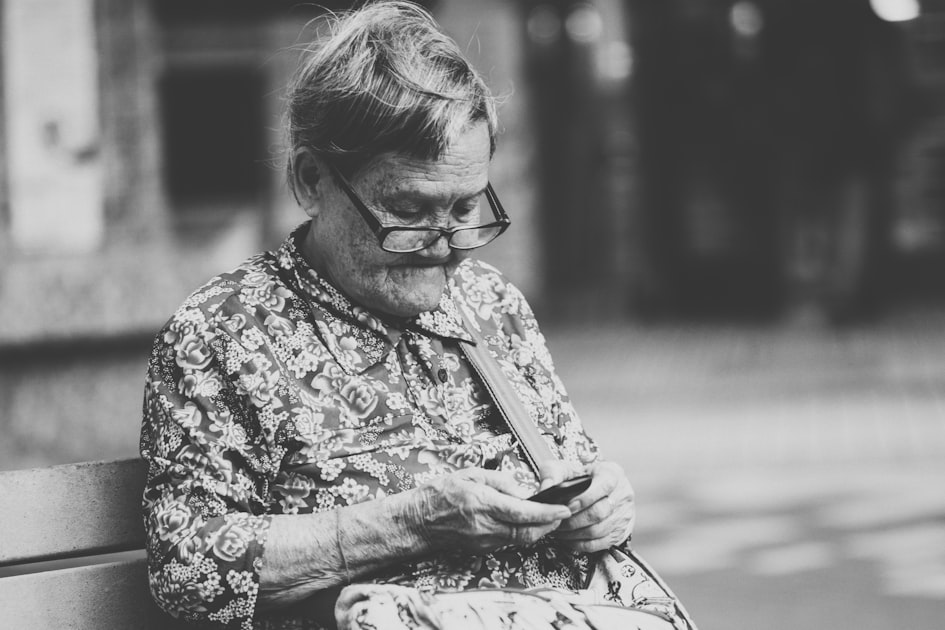 selective focus grayscale photography of woman using phone while sitting at bench — Sim Viettel Cho Người Già — Dễ Sử Dụng...